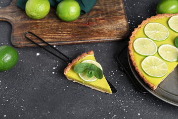 Wall Mural - Plate and spatula with tasty lime tart on black background