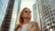 © Anzhela - Stylish businesswoman in sunglasses standing tall amidst skyscrapers