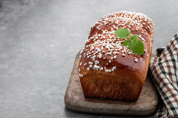 Sweet white loaf with sugar sprinkles on gray background