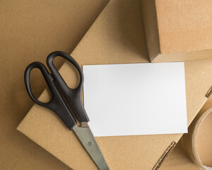 white blank letterhead on a background of tape scissors and packing cartons. online sales and Packages delivered