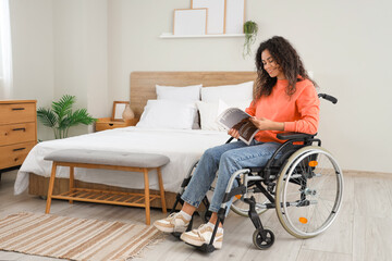 Sticker - Young African-American woman in wheelchair reading magazine at home