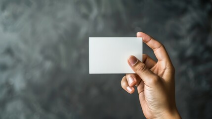 A hand holding a white business card