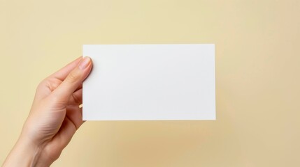 A hand holding a blank piece of paper