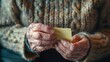 © Justlight - A closeup of wrinkled hands holding a Postit note with a phone number written in large print aiding in memory recall