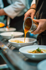 Wall Mural - A person is pouring a sauce into a bowl of food