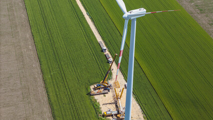 Wall Mural -  sustainable electrical energy production. Aerial installation of Wind Turbine generator on a construction site on an agricultural field