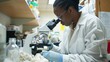 © Lakkhana - A forensic analyst in a lab examining clothing and other evidence under a microscope