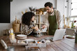 © sofiko14 - Male and female artists working on pottery project in bright studio. Teacher assisting student in sculpting clay piece
