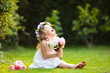 © famveldman - Little girl with flower bouquet in sunny garden
