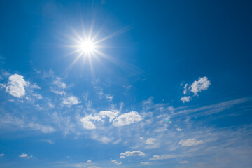 sparkle sun on blue cloudy sky background