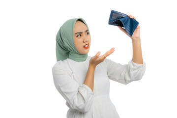 Wall Mural - Surprised young Asian woman in green hijab and white blouse holding and shaking his empty wallet, searching for cash isolated on white background