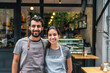 © eshana_blue - Young cheerful couple managing small business, owning coffee shop, portrait in front of the glass doors.