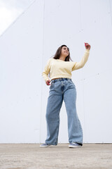 Wall Mural - plus size woman wearing casual clothes dancing on white wall background in the street