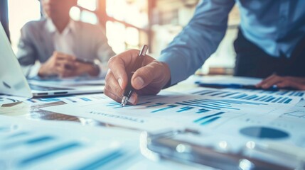 Poster - A businessman sits at a table with colleagues, reviewing charts and graphs.