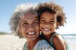 © vefimov - A mother holds her child on a sunny beach, providing a safe and loving environment