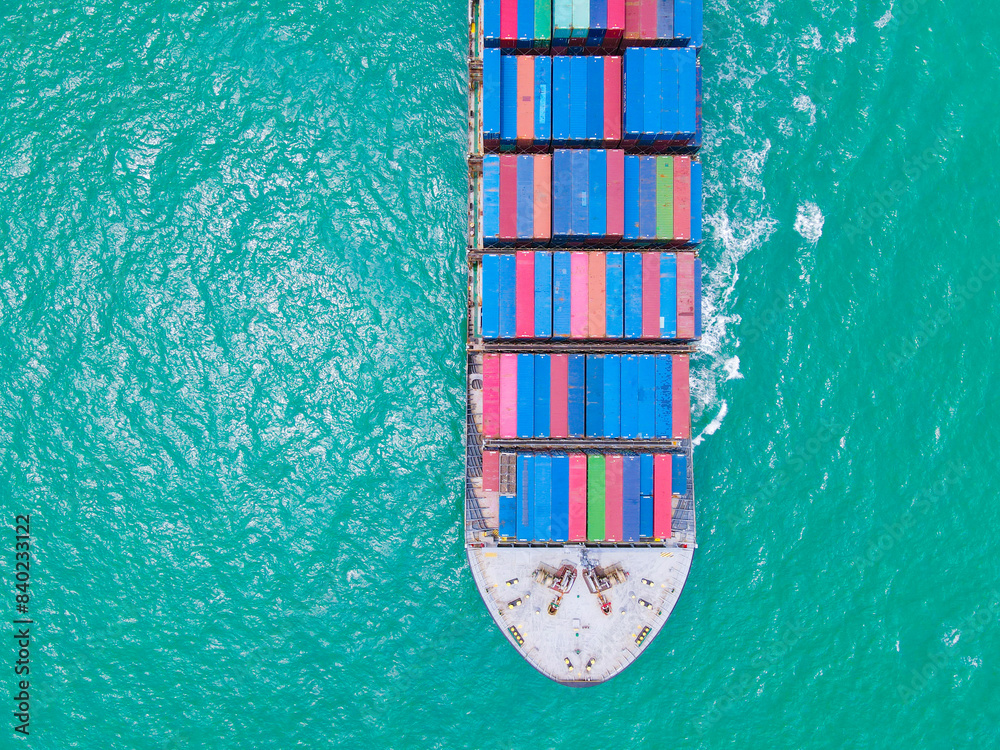 the aerial perspective of a cargo ship being loaded and unloaded at a ...