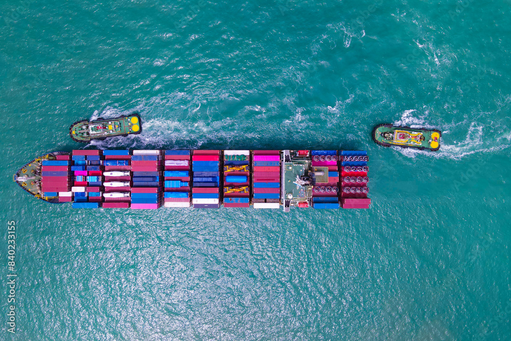 the aerial perspective of a cargo ship being loaded and unloaded at a ...