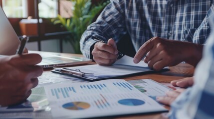 Poster - A close-up image of a group of business professionals reviewing financial data during a meeting, with a focus on charts and graphs.