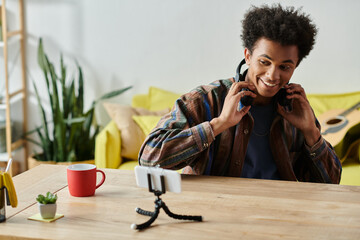 Wall Mural - A young man with headphones and coffee, chatting on the phone.