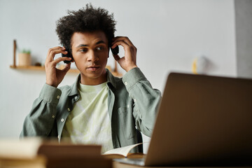 Wall Mural - Young man immersing in laptop tunes.