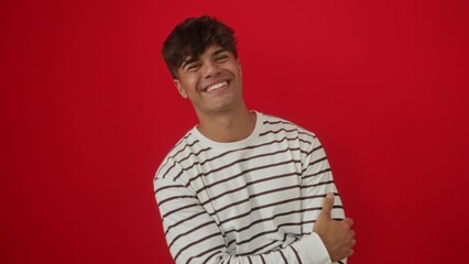 Poster - Funny young hispanic man wearing stripes t shirt standing making crazy fish face expression over isolated red background, comical lips gesture showing fun and silly attitude