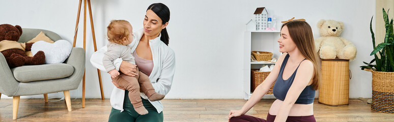 Wall Mural - A young, beautiful mother tenderly holds her baby in a warm and inviting living room, guided by her supportive coach from parents courses.