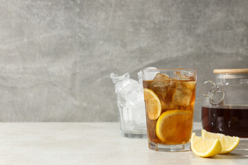 Wall Mural - A glass of cold tea with ice and an orange