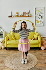 A young girl with a prosthetic leg smiles while playing with a hula hoop in her living room.