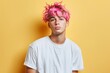 © Dina - young diverse guy non binary person with pink hair wearing blank white t-shirt on pastel yellow wall background with copy space