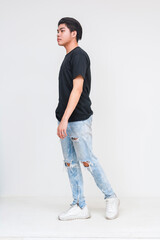 Wall Mural - Young Asian man walking in casual outfit and torn jeans