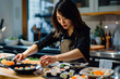 © Di Studio - portrait of asian woman cooking sushi at the kitchen