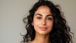 © World of AI - Middle Eastern woman softly smiling, glowing skin, with long, curly dark hair, wearing a dewy foundation and soft pink blush, neutral cream background
