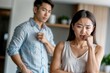 © polack - Asian woman is crying in front of a man on kitchen, family problems. The man is trying to comfort her. Scene is sad and emotional