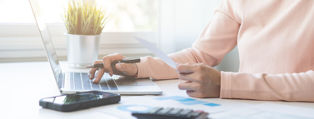 Wall Mural - Deduction planning online asian young woman hand using laptop computer to calculate money balance from bill and income, cost budget expenses for pay money form personal individual on table at home.