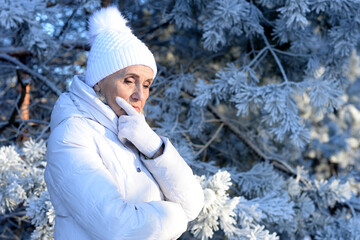 Wall Mural - Beautiful elderly woman posing in a snowy winter park