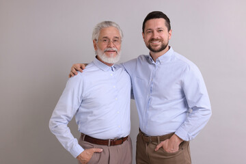 Wall Mural - Happy son and his dad on gray background