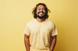 © CogniLens - Portrait of a joyful indian man in his 30s donning a trendy cropped top isolated on pastel yellow background