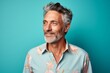 © CogniLens - Portrait of a tender man in his 50s sporting a technical climbing shirt isolated on pastel teal background