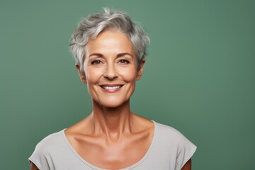 Wall Mural - Portrait of a smiling woman in her 50s dressed in a breathable mesh vest over soft green background