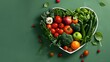 © TigerDude - Top view of heart shape bowl with fresh vegetables and fruits on green background, concept for healthy eating or dieting