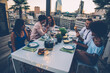 © oneinchpunch - Group of friends having fun on the rooftop of a beautiful rooftop. Young people celebrating on a modern terrace with the view at the aperitif time.