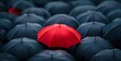 © TigerDude - red umbrella standing out from the crowd of black umbrellas, symbolizing different thinking and unique ideas in business