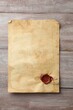 © New Africa - Sheet of old parchment paper with wax stamp on wooden table, top view