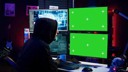 Wall Mural - Hacker using AI and green screen computer monitors to produce malicious malware corrupt company data. Evil man working on mockup desktop PC using artificial intelligence, infecting systems, camera B