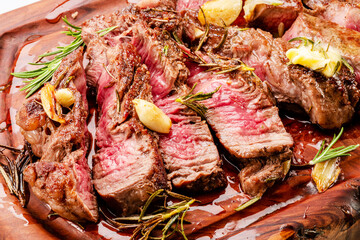 Poster - Sliced juicy medium rib eye steak on wooden board. Top view.