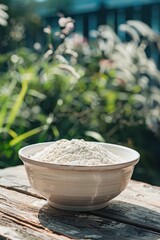 Wall Mural - flour in a white bowl on a wooden table. Selective focus