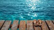© Otseira - Flip-flops on wood against blue water background. Summer vacation concept