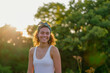 © marie - Belle femme métisse souriante au soleil dans un parc