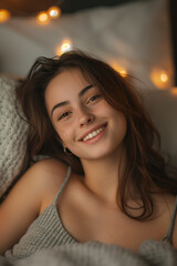 Wall Mural - Caucasian woman lying on bed and smiling looking at camera.