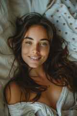 Wall Mural - Caucasian woman lying on bed and smiling looking at camera.